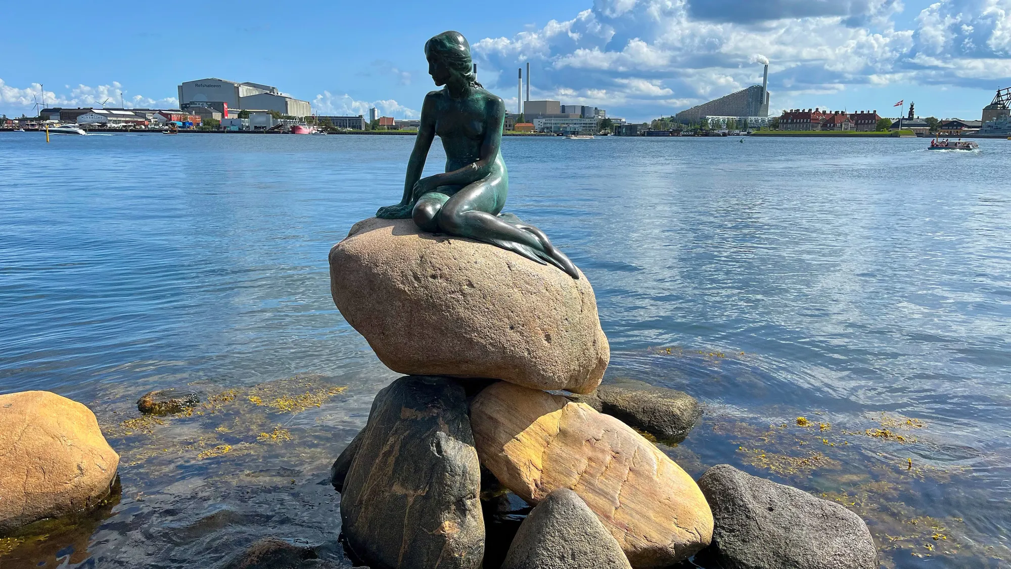 Bronze statue of the little mermaid overlooking the harbor