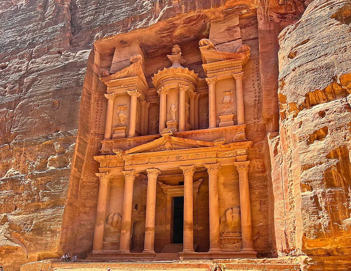 Iconic two story carved structure out of the orange rock face with columns and statues in tact