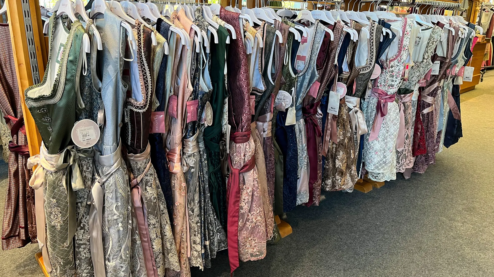 A clothing rack filled with dirndls for sale in an assortment of colors