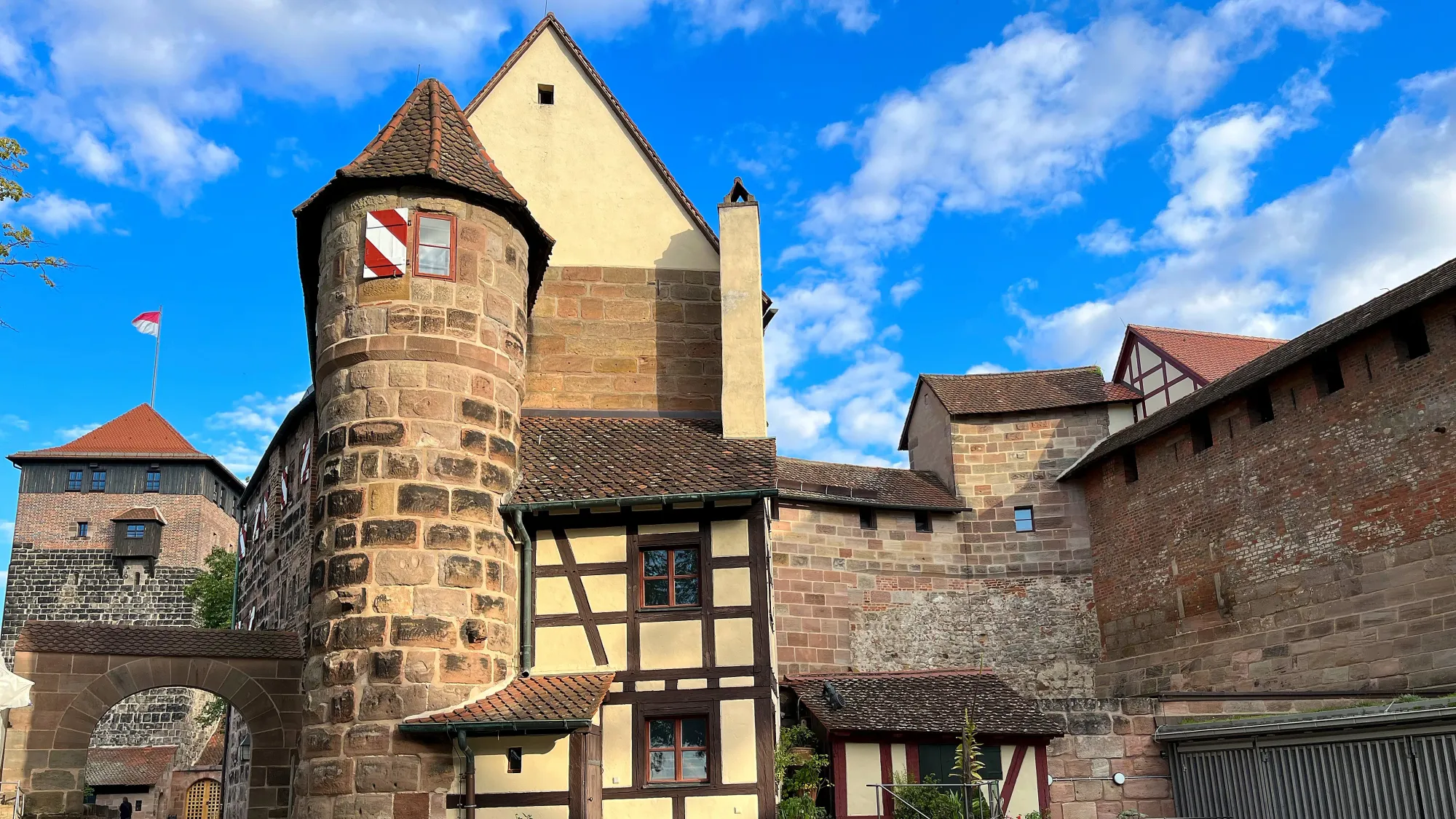 Stone towers along brick walls with a German flag flying