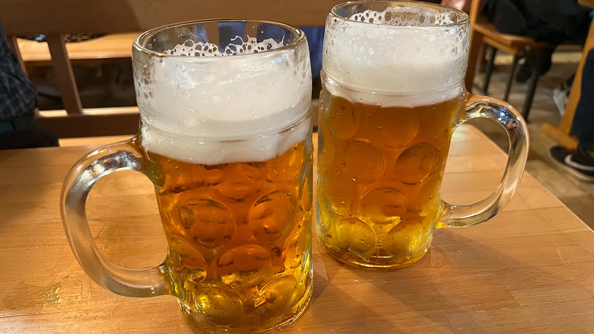 Two colorless glasses filled with foamy beer