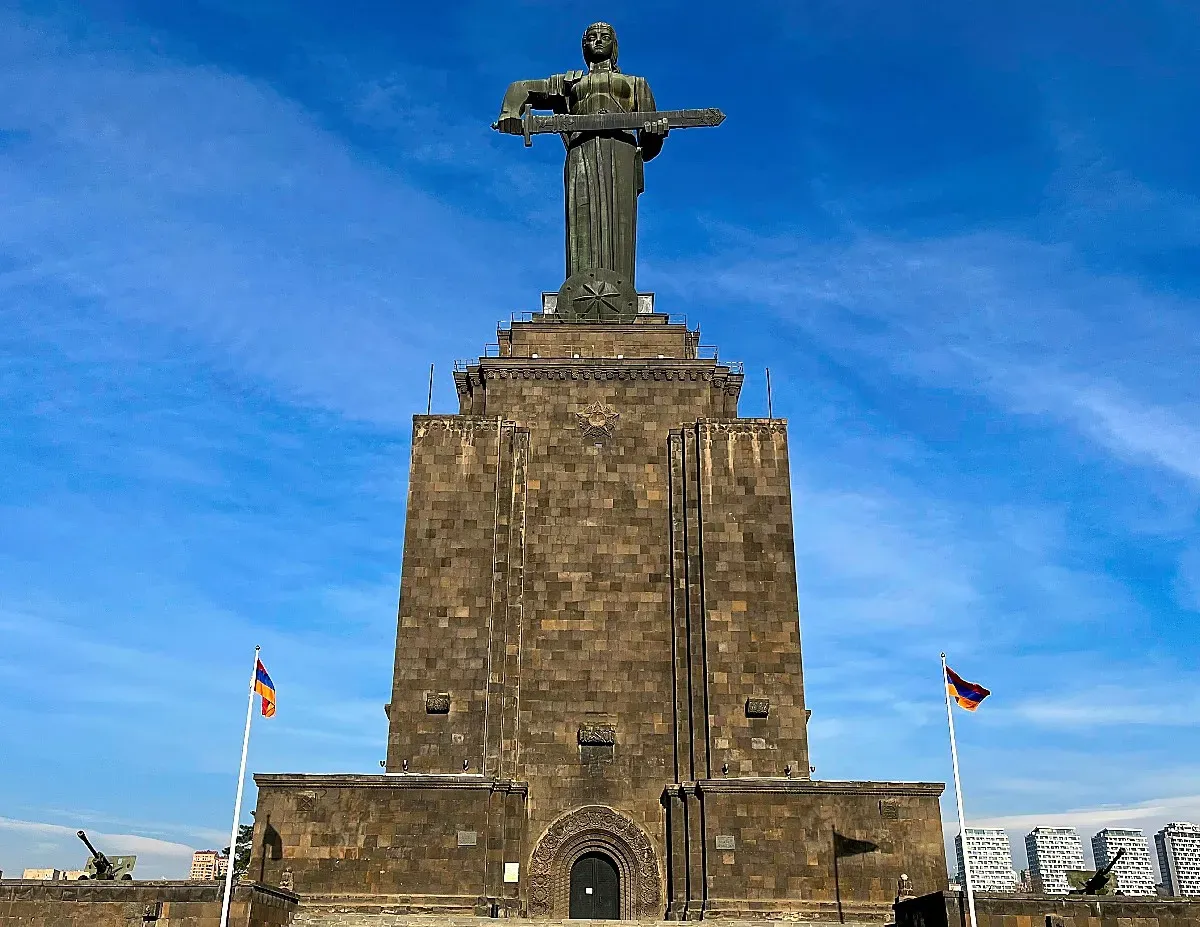 Female Statue holding a sword flanked by two Armenian flags