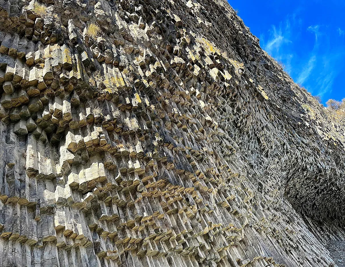 Thousands of grey basalt pillars handing from the rock wall