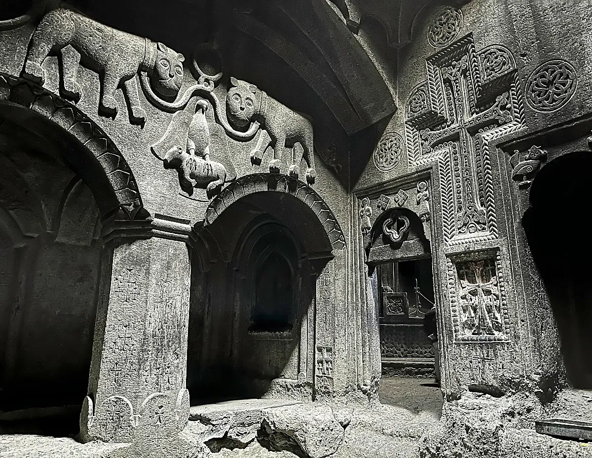 Grey stone walls carved with animals and crosses over archways