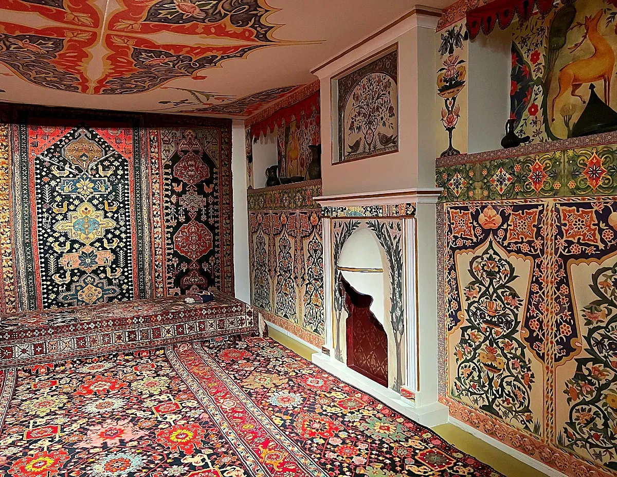 A room covered ceiling to floor in paintings of carpets