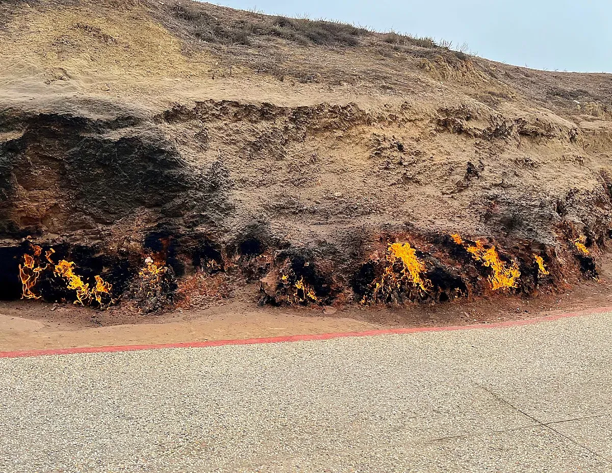 Brown hillside in flames from unseen gaseous fuel