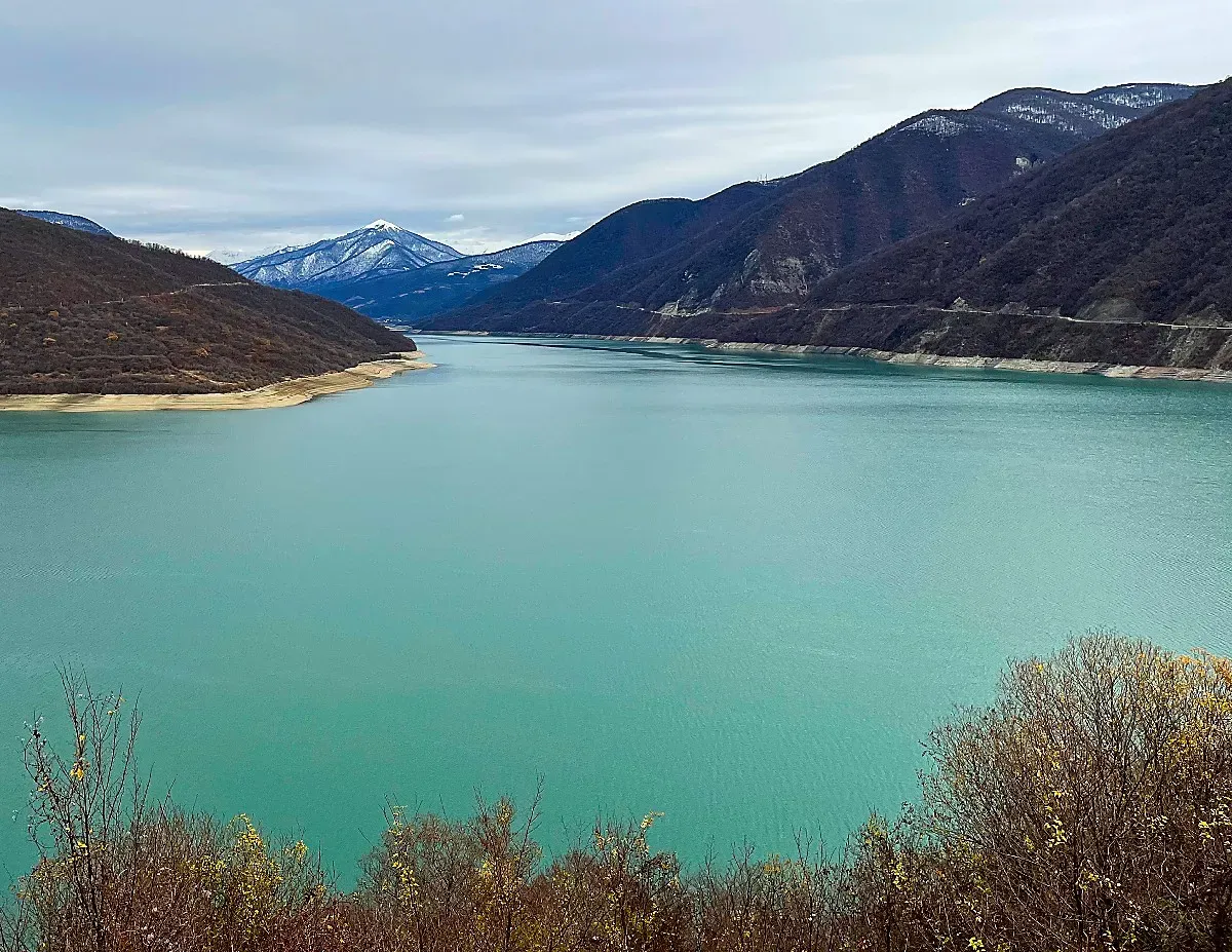 Aqua colored reservoir set against tall dark mountains
