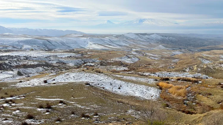 Snow covered hills with a misty mountain in the background