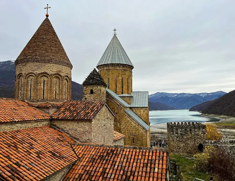 Rounded stone towers and shingled roofs overlooking a lake