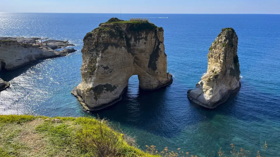 Teal ocean with multi-layered arch shaped rock protruding