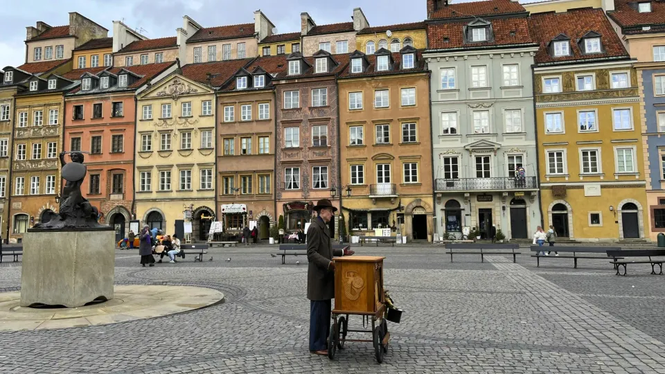 Multicolored building facades with a musician in the center of the square