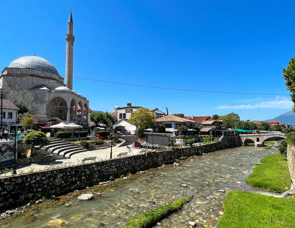 Stream running in front of a stone faced mosque