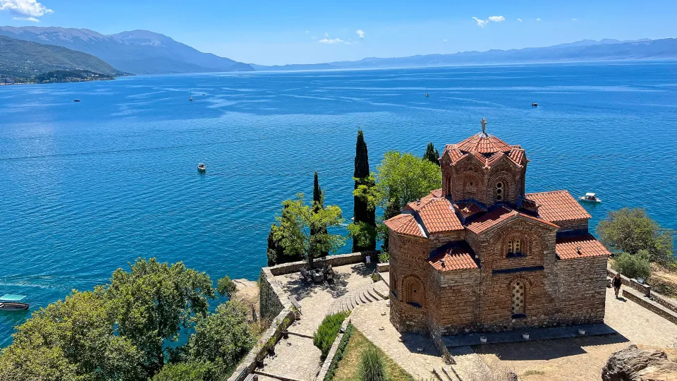 Red brick church overlooking a shockingly blue lake